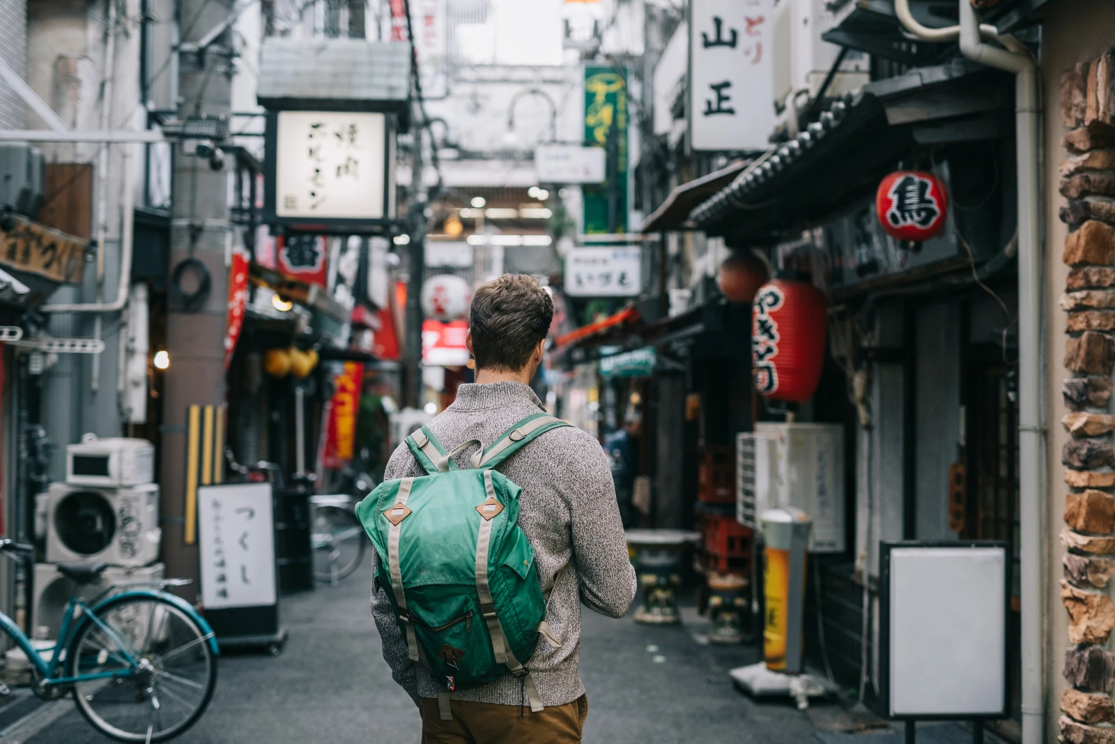 A traveler exploring a quiet, local side street in Japan away from the usual tourist crowds.